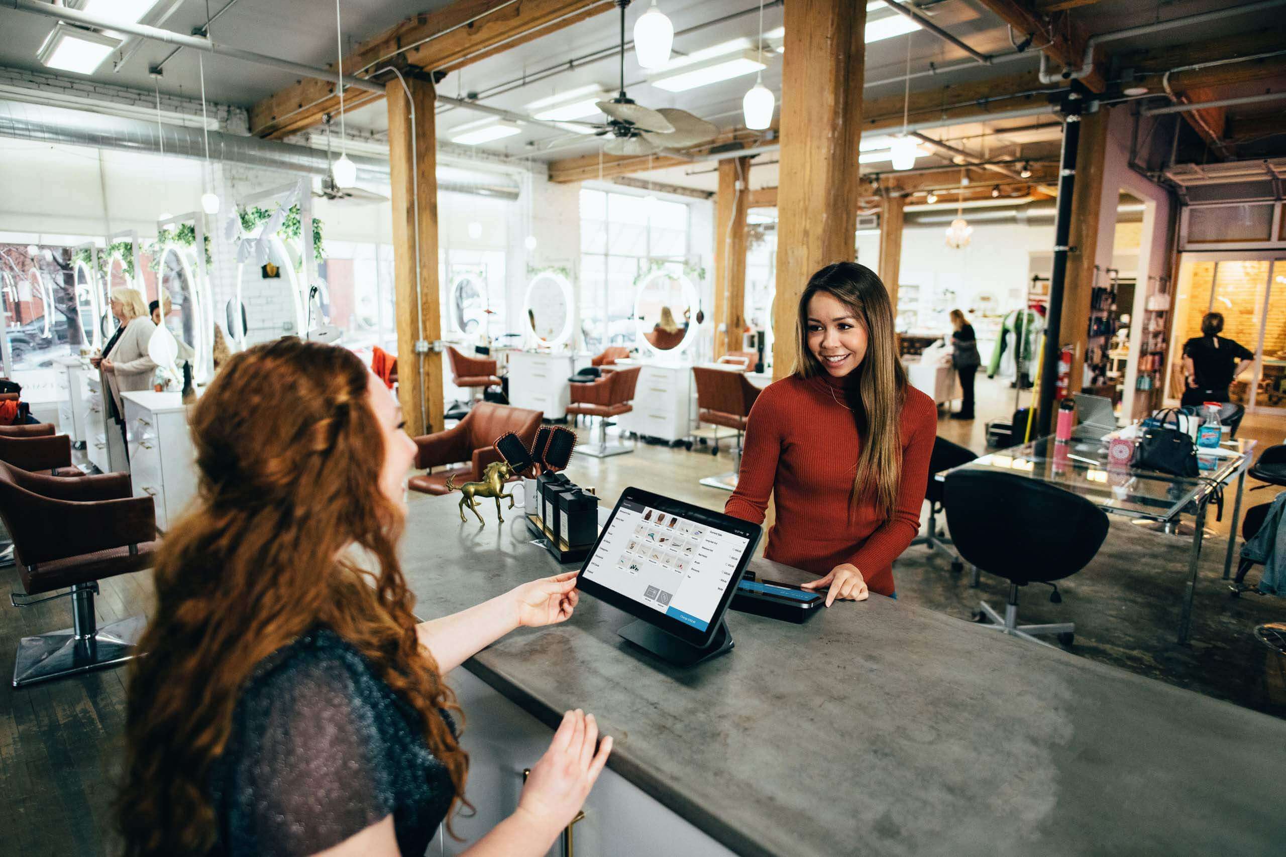 Woman making a purchase with cashier at a small business